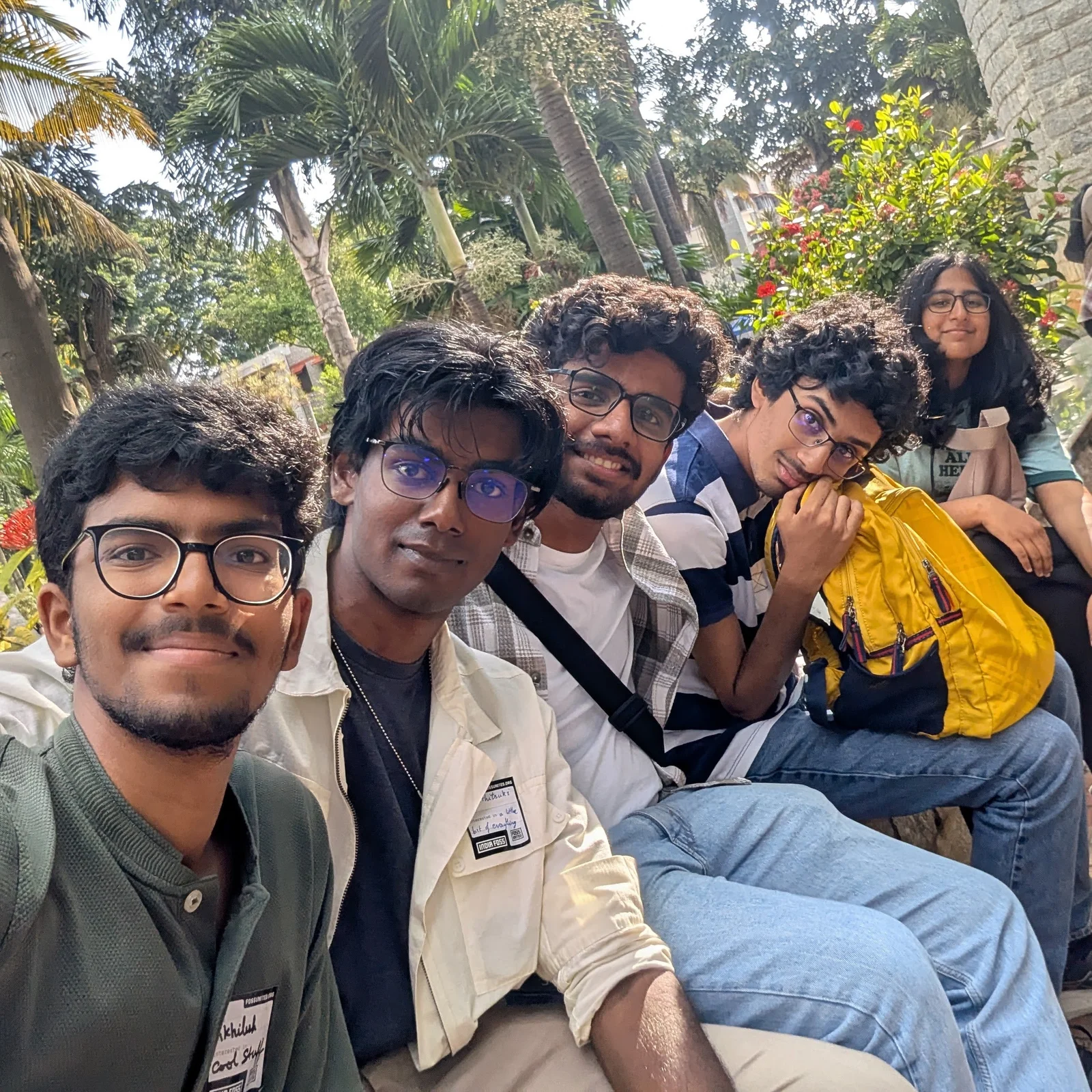 All five of us on a bench outside, under the palm trees.