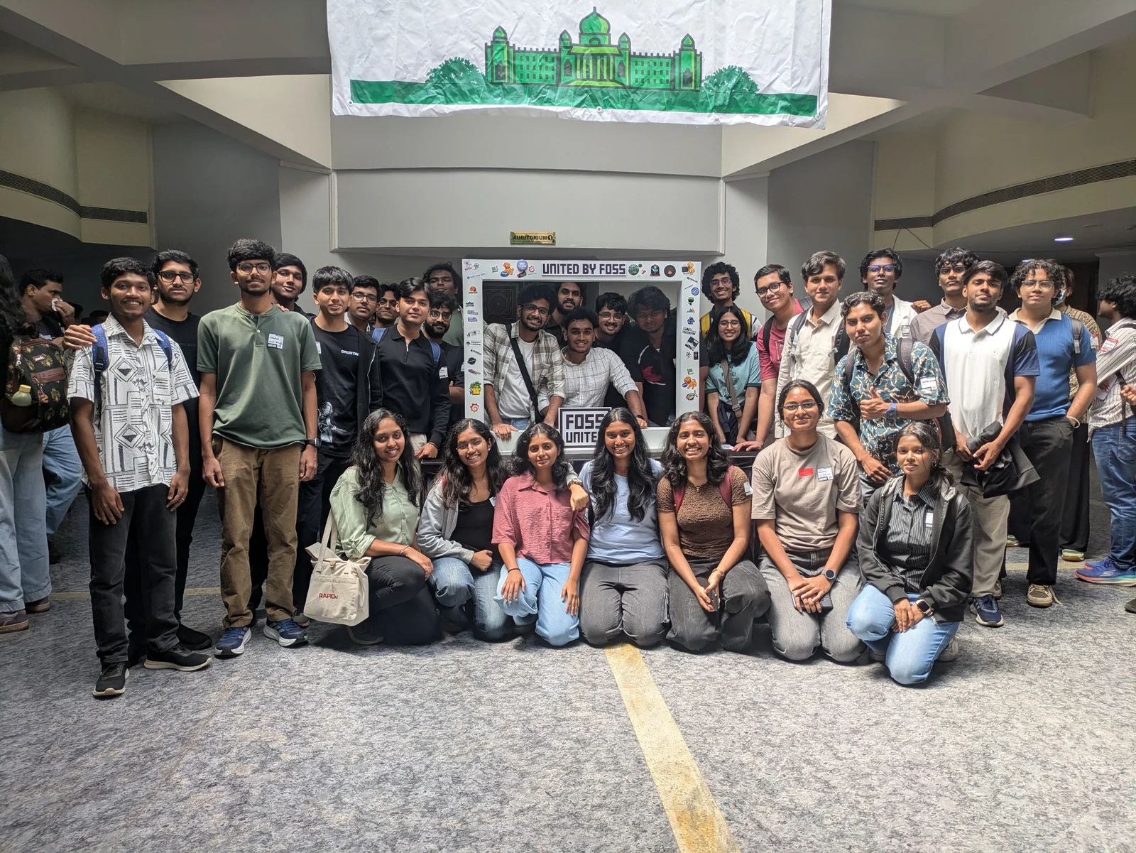 The rest of us from Amrita, posing in front of a United By FOSS board.