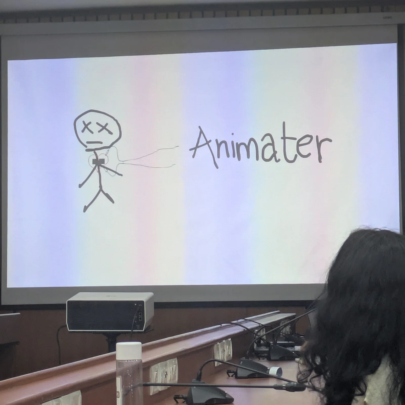 A talk slide showing a hand-drawn stick figure with X eyes beside the misspelled word Animater.